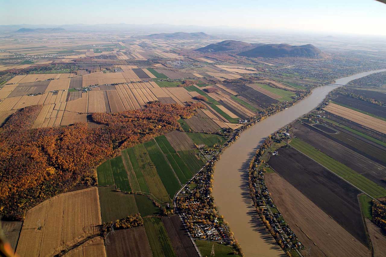 Aerial view of the Monteregian plain and the Richelieu River in the fall; the forest corridors can be seen among the farm plots